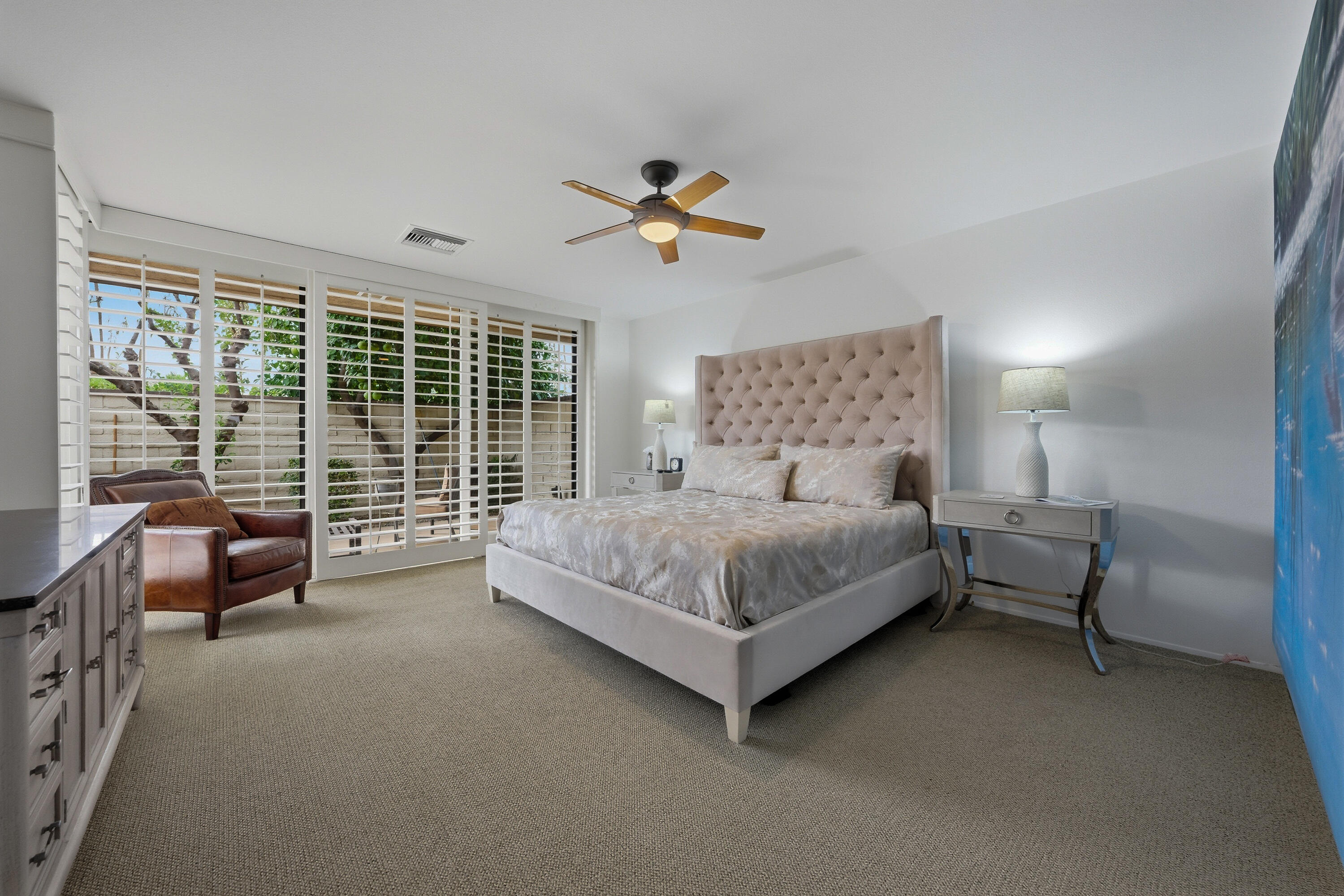 27 Cornell Drive Rancho Mirage, CA 92270 - Photo 18 of 58 a bedroom with a bed and a chandelier
