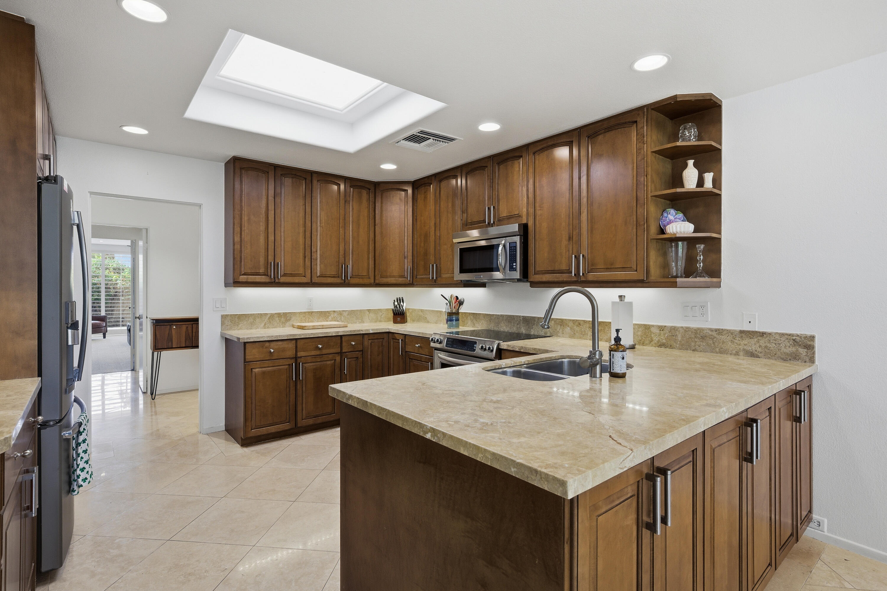27 Cornell Drive Rancho Mirage, CA 92270 - Photo 9 of 58 a kitchen with kitchen island granite countertop a sink counter top space appliances and cabinets