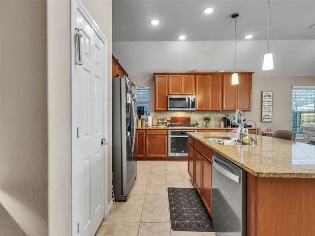 a kitchen with stainless steel appliances kitchen island granite countertop a sink and cabinets