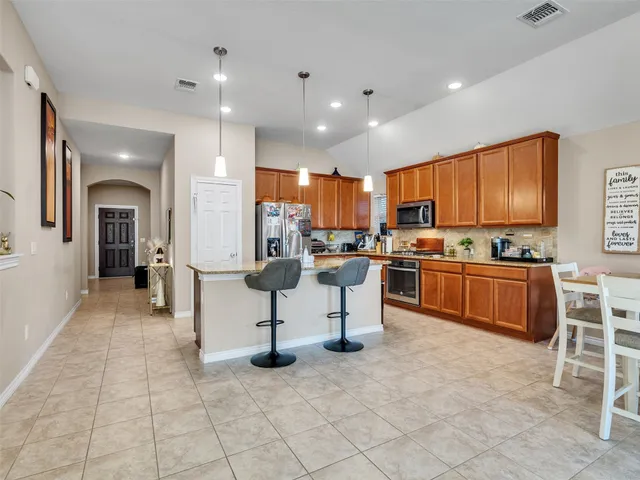 a kitchen with stainless steel appliances kitchen island granite countertop a sink and cabinets