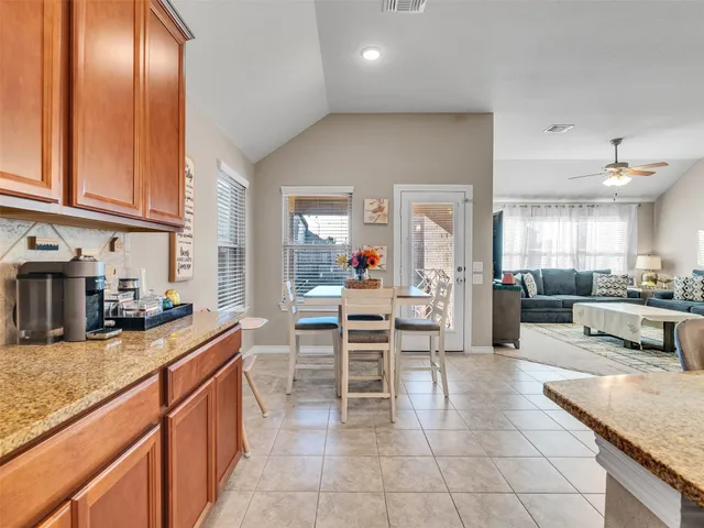 a kitchen with stainless steel appliances kitchen island granite countertop a refrigerator and a stove top oven