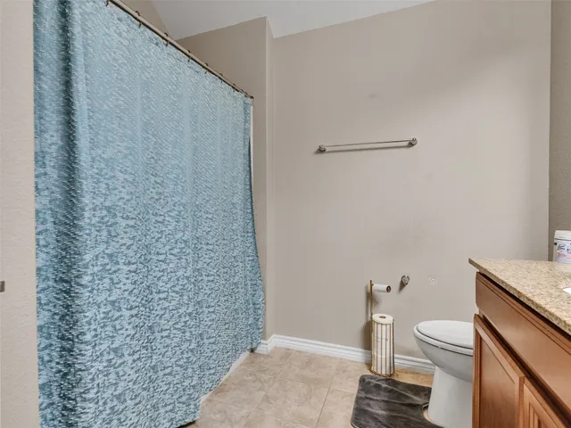a bathroom with a granite countertop toilet and a sink