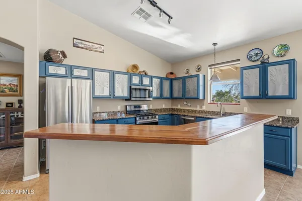 a kitchen with granite countertop white cabinets and stainless steel appliances