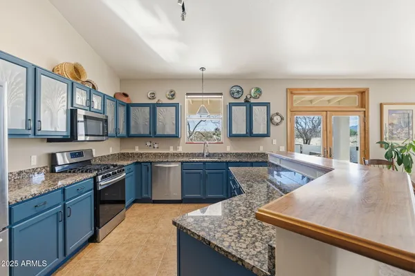 a spacious bedroom with a bed a dresser and wooden floor