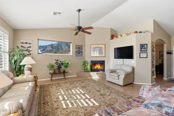 a living room with furniture a flat screen tv and a fireplace