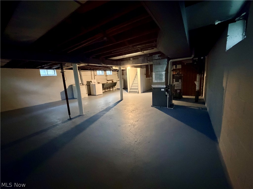 10506 Park Heights Road Cleveland, OH 44104 - Photo 22 of 22 Spacious unfinished basement featuring painted concrete flooring, exposed ceiling joists, and multiple windows