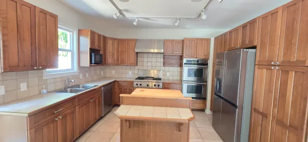 a kitchen with stainless steel appliances a sink window and refrigerator