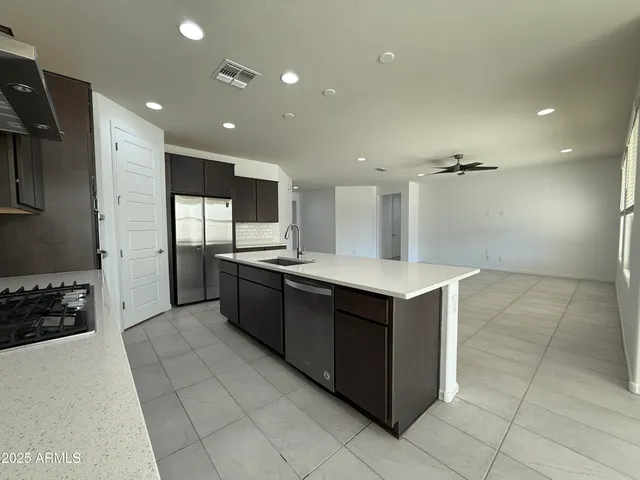 a kitchen with stainless steel appliances kitchen island granite countertop a stove and a refrigerator