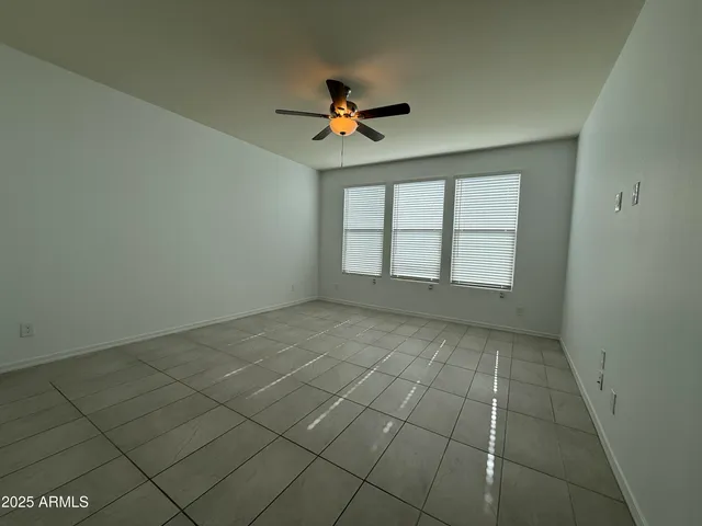 an empty room with windows and fan