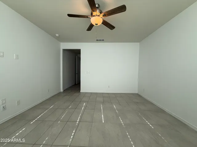 an empty room with closet and a chandelier fan