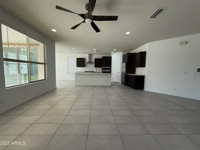 a view of a big room with windows and chandelier fan