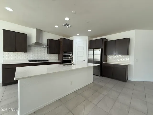 a large white kitchen with a stove a sink and a microwave