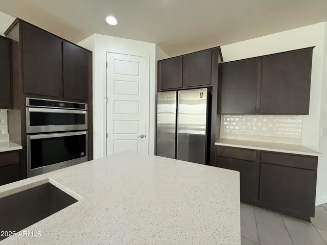 a kitchen with granite countertop stainless steel appliances and refrigerator