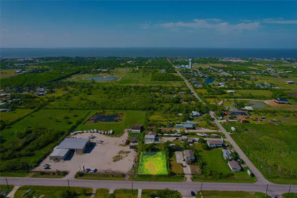 an aerial view of residential houses with outdoor space and trees