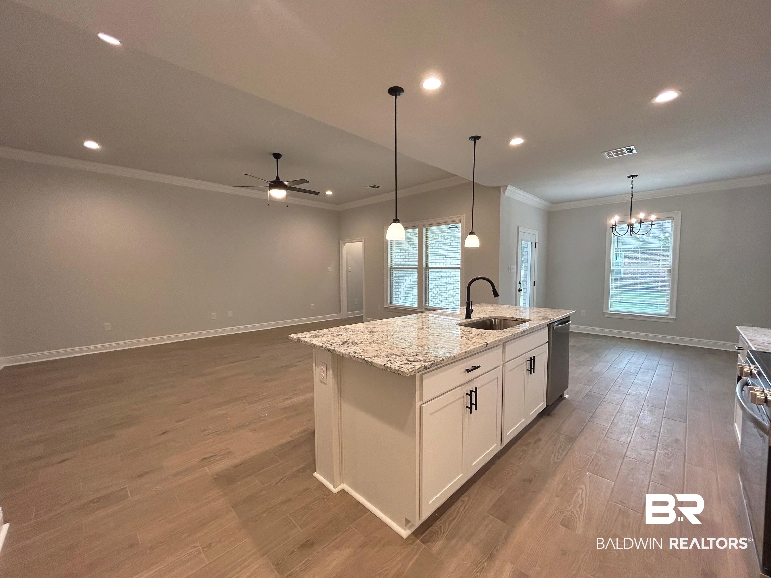 860 Sumter Loop Foley, AL 36535 - Photo 5 of 26 Kitchen featuring white cabinets, sink, a center island with sink, stainless steel appliances, and ceiling fan with notable chandelier