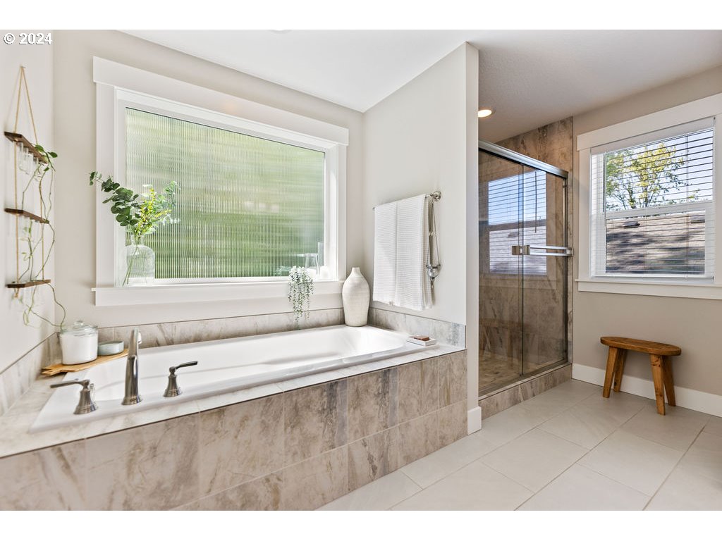 327 South 39th Drive Ridgefield, WA 98642 - Photo 26 of 48 a bathroom with a sink a bathtub and a large mirror