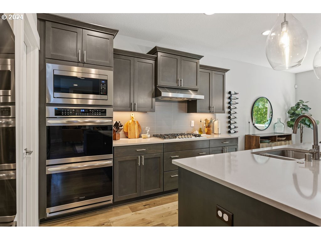 327 South 39th Drive Ridgefield, WA 98642 - Photo 8 of 48 a kitchen with stainless steel appliances a stove a sink and a microwave