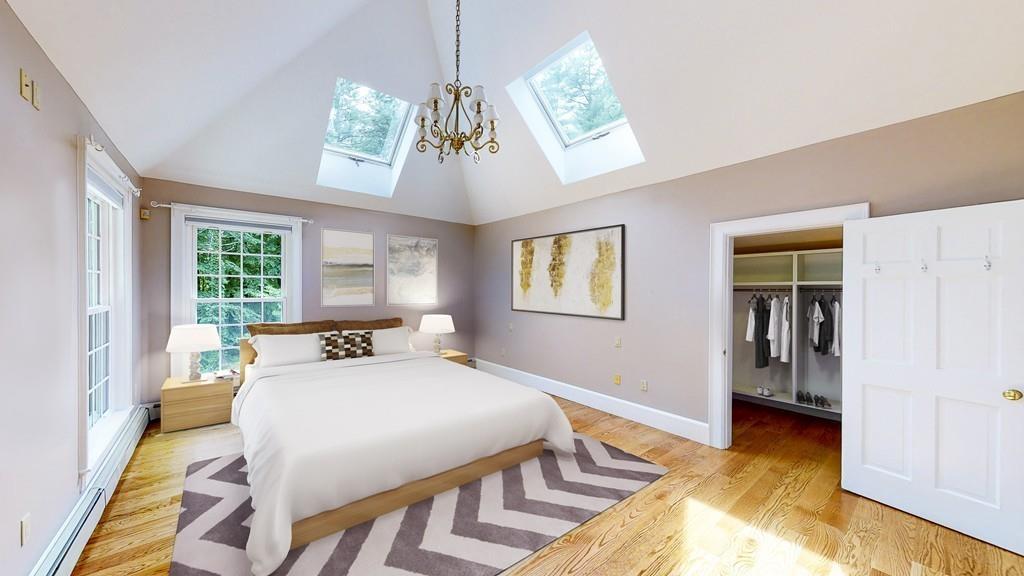5 Duston Lane Acton, MA 01720 - Photo 22 of 39 a bedroom with a bed and a chandelier