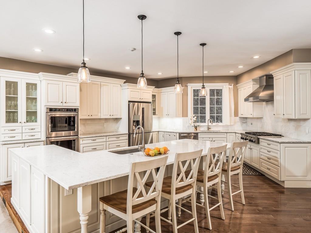 5 Duston Lane Acton, MA 01720 - Photo 10 of 39 a kitchen with stainless steel appliances kitchen island granite countertop a table chairs stove and white cabinets