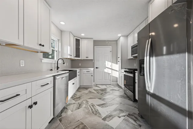 a large kitchen with cabinets stainless steel appliances and a counter top