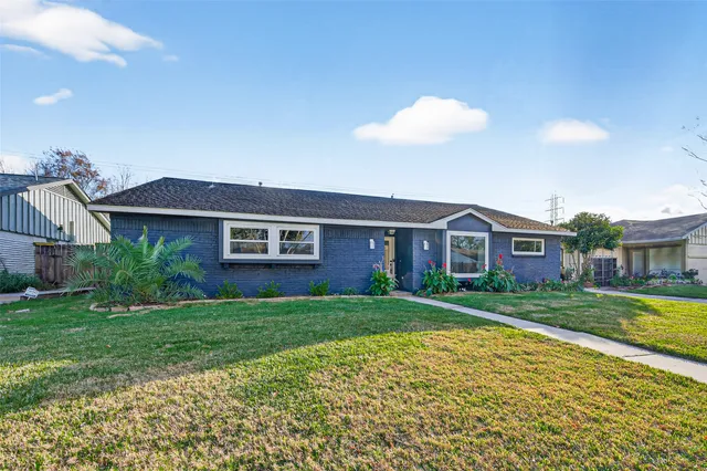 a view of a yard in front of a brick house with a yard