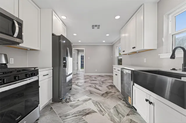 a kitchen with refrigerator cabinets and a stove top oven