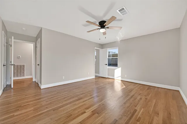 a view of an empty room with wooden floor