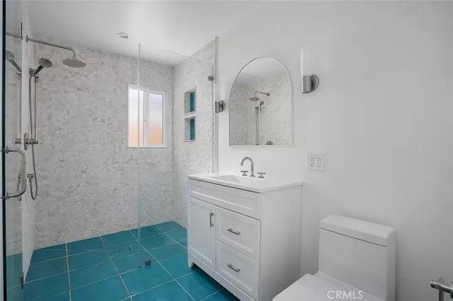 a bathroom with a toilet a sink a mirror and a shower