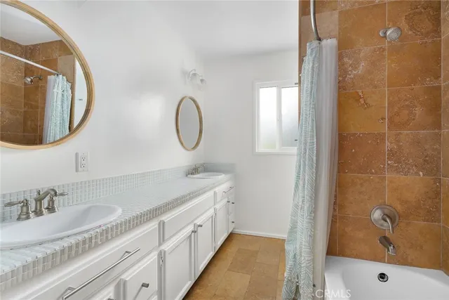 a bathroom with a granite countertop sink mirror and a bathtub