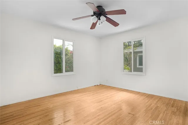 an empty room with a window and a fan