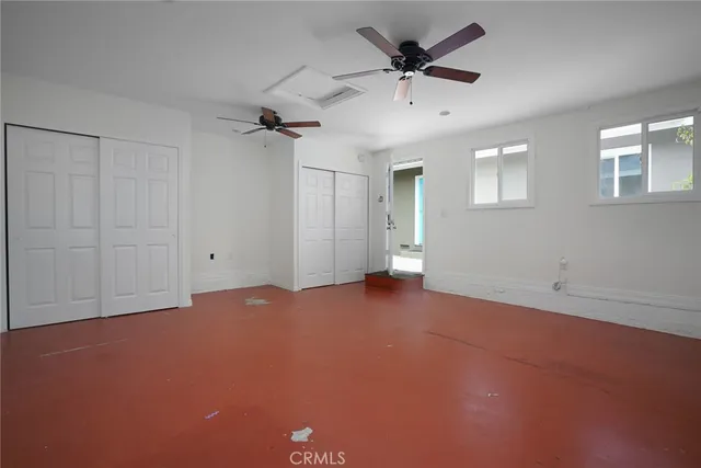 an empty room with a ceiling fan and a window