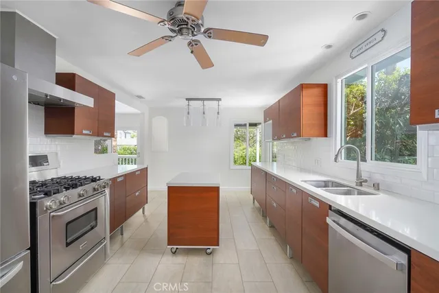 a kitchen with stainless steel appliances granite countertop a sink a stove top oven a counter space and cabinets