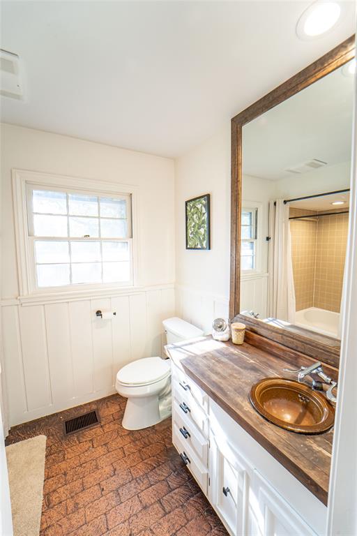 4 Sendero Road Breckenridge, TX 76424 - Photo 21 of 38 Ensuite Guest Bathroom for Guest Bedroom#2 featuring wainscoting, shower / bath combination and brick flooring!