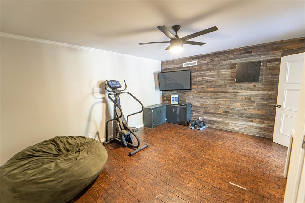 4 Sendero Road Breckenridge, TX 76424 - Photo 27 of 38 Rare 4th Guest Bedroom option with full-size closet offers versatility of a home office, personal gym or hobby room-featuring wooden accent wall and unique brick flooring!