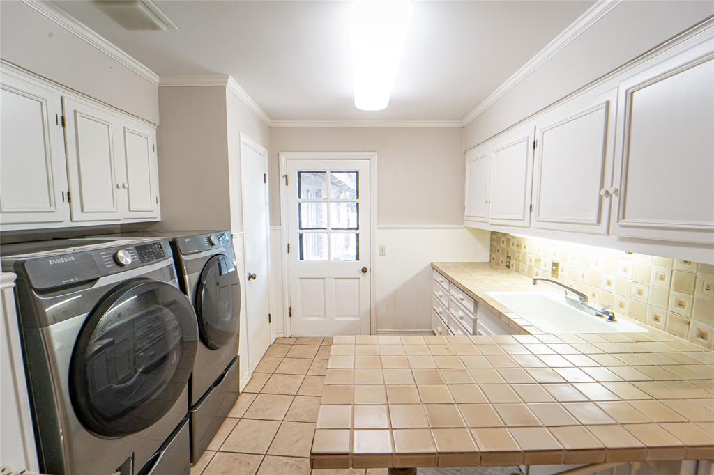 4 Sendero Road Breckenridge, TX 76424 - Photo 29 of 38 Large and spacious, the Laundry area offers a soaking sink, ample storage and counter space, while giving outdoor access to a shaded, separately fenced dog run.