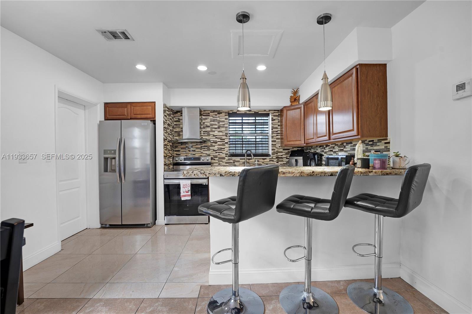 6841 Raleigh Street Hollywood, FL 33024 - Photo 11 of 41 a kitchen with stainless steel appliances granite countertop a refrigerator and a stove top oven