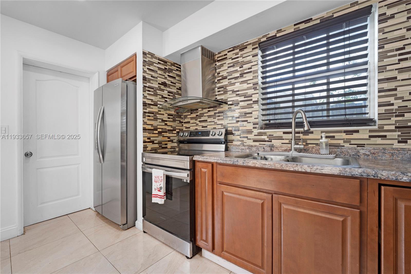 6841 Raleigh Street Hollywood, FL 33024 - Photo 14 of 41 a kitchen with stainless steel appliances granite countertop a sink and a refrigerator