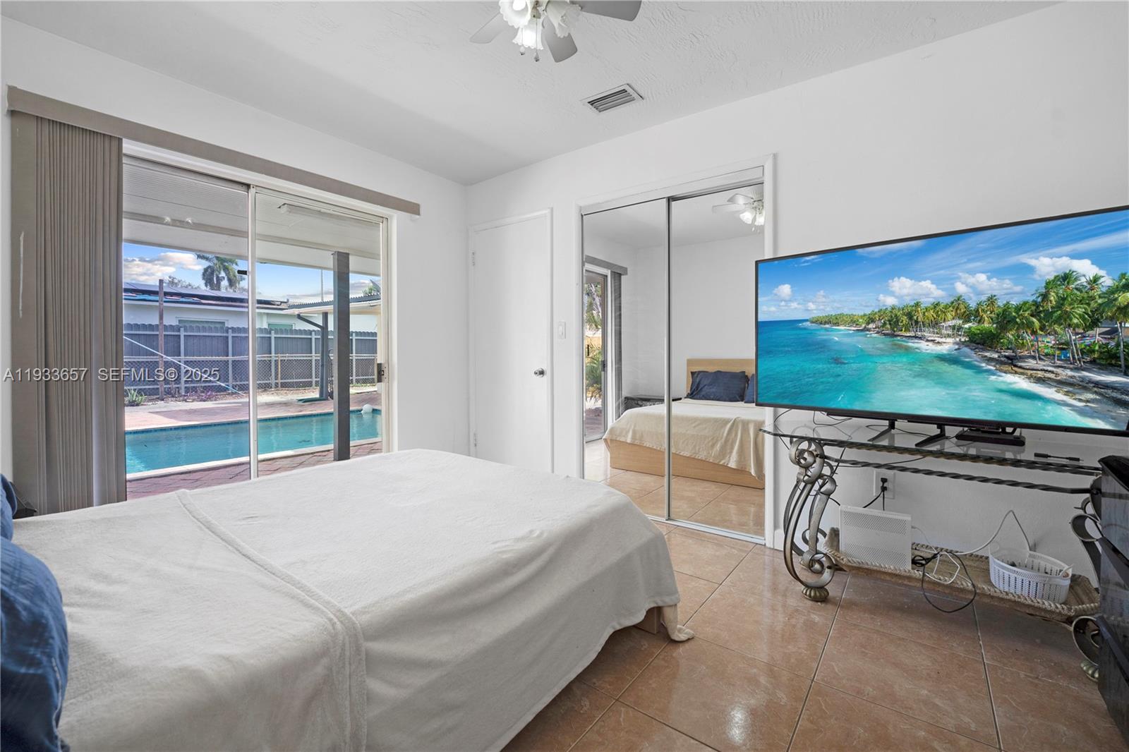 6841 Raleigh Street Hollywood, FL 33024 - Photo 17 of 41 a spacious bedroom with a bed and a flat screen tv