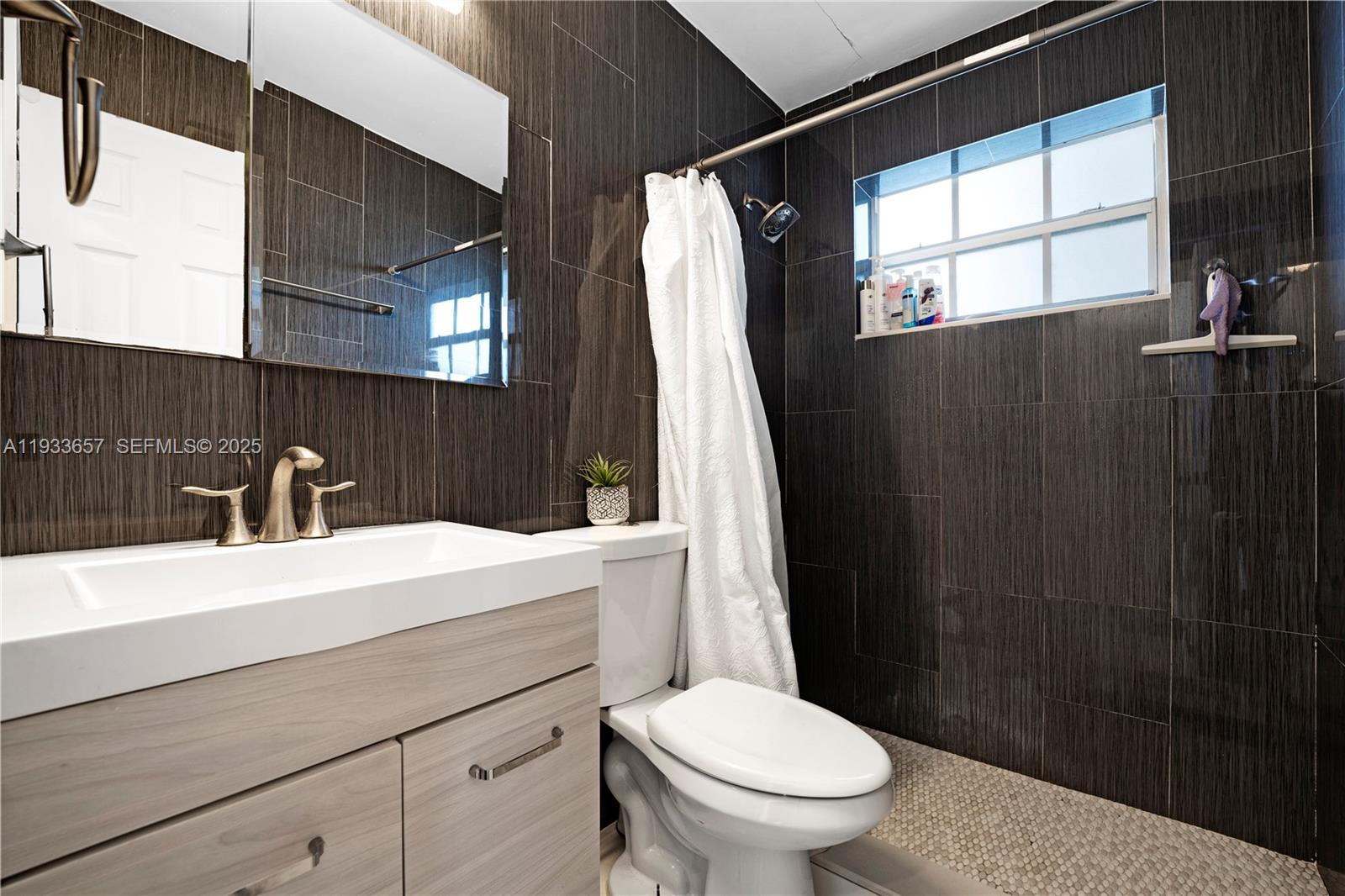 6841 Raleigh Street Hollywood, FL 33024 - Photo 20 of 41 a bathroom with a sink a toilet a mirror and a shower