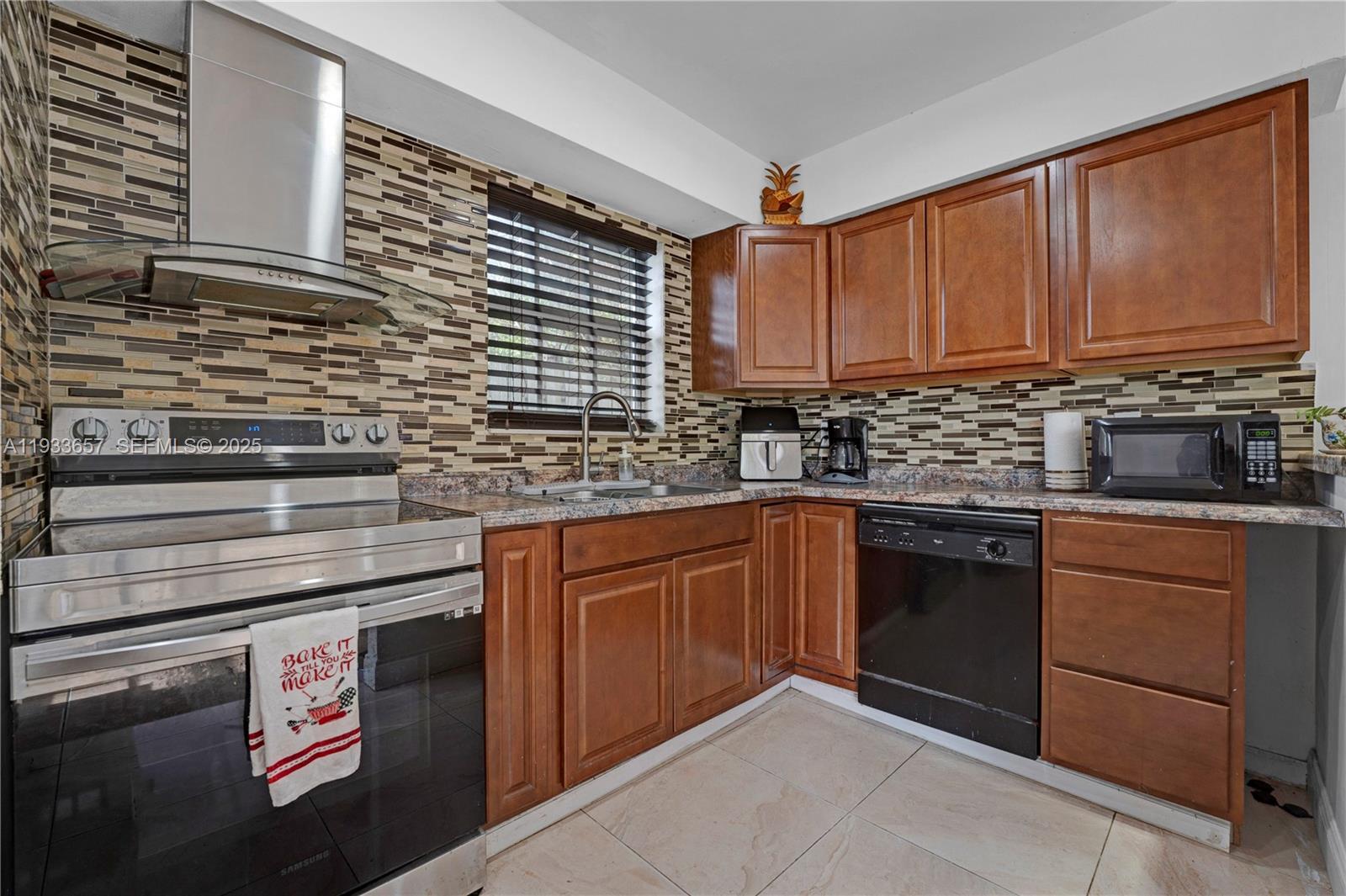6841 Raleigh Street Hollywood, FL 33024 - Photo 2 of 41 a kitchen with stainless steel appliances granite countertop a sink stove and cabinets