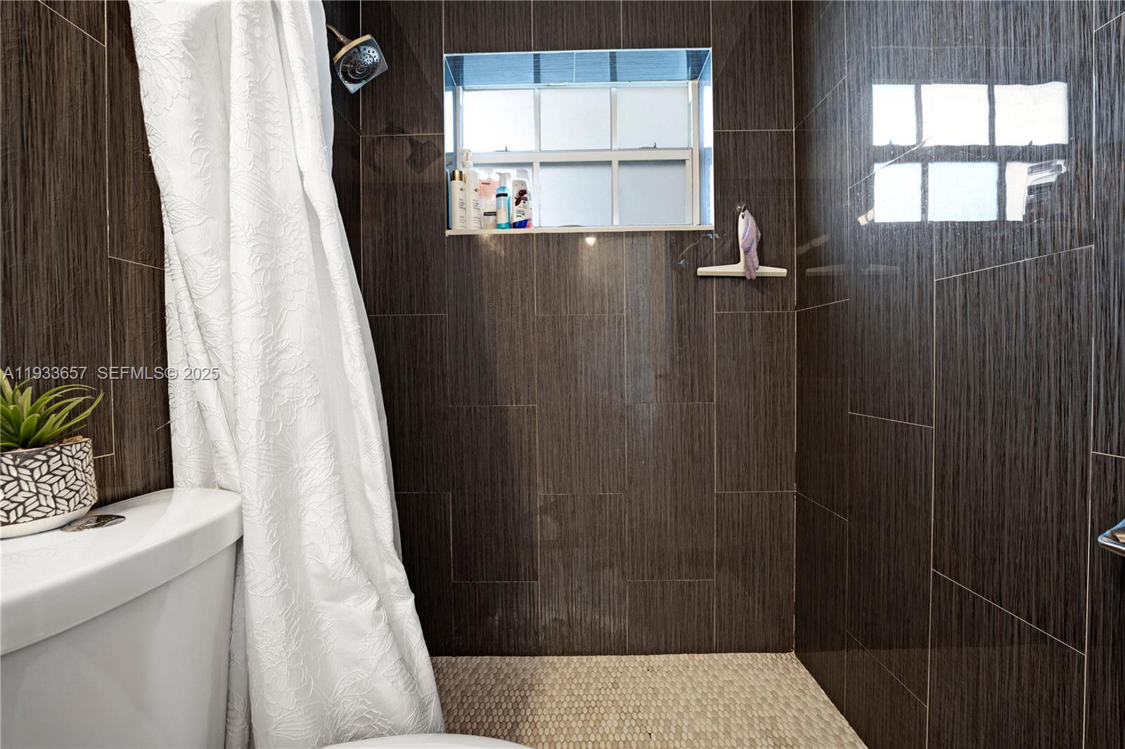 6841 Raleigh Street Hollywood, FL 33024 - Photo 21 of 41 a bathroom with a window and shower