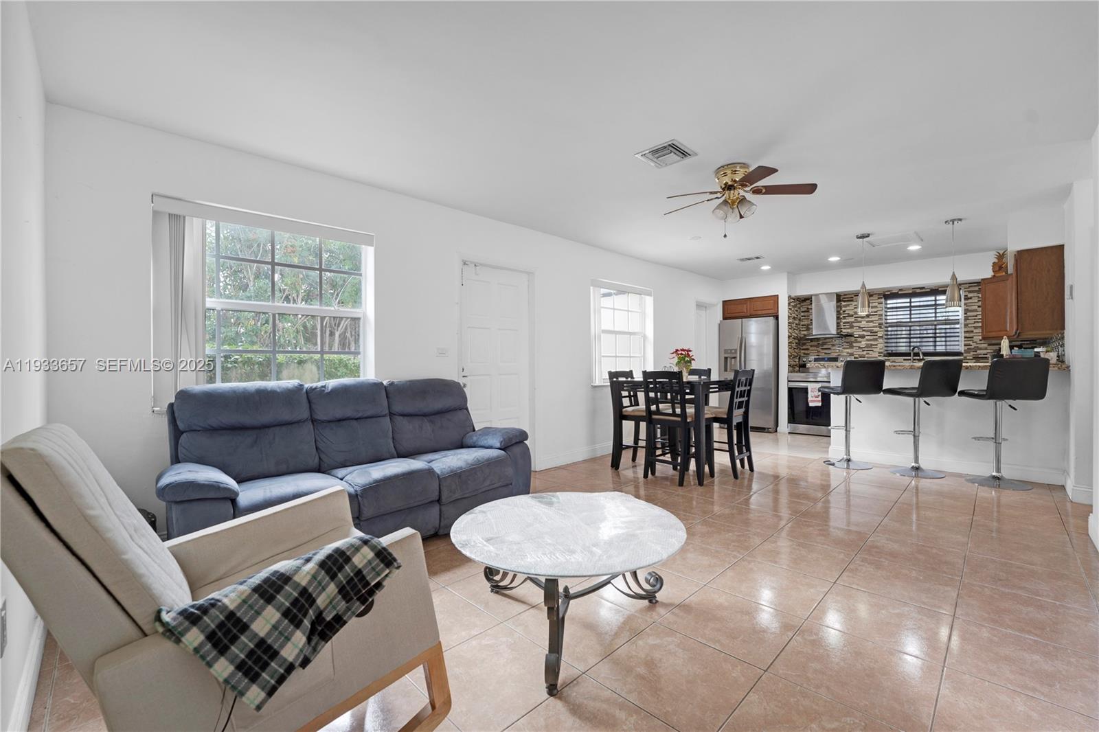 6841 Raleigh Street Hollywood, FL 33024 - Photo 29 of 41 a living room with furniture and a dining table with kitchen view