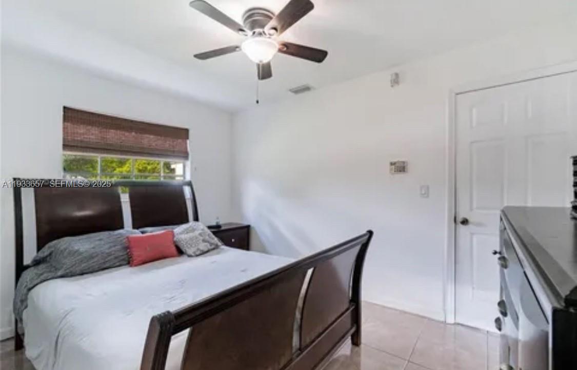 6841 Raleigh Street Hollywood, FL 33024 - Photo 41 of 41 a bedroom with a bed and a chandelier