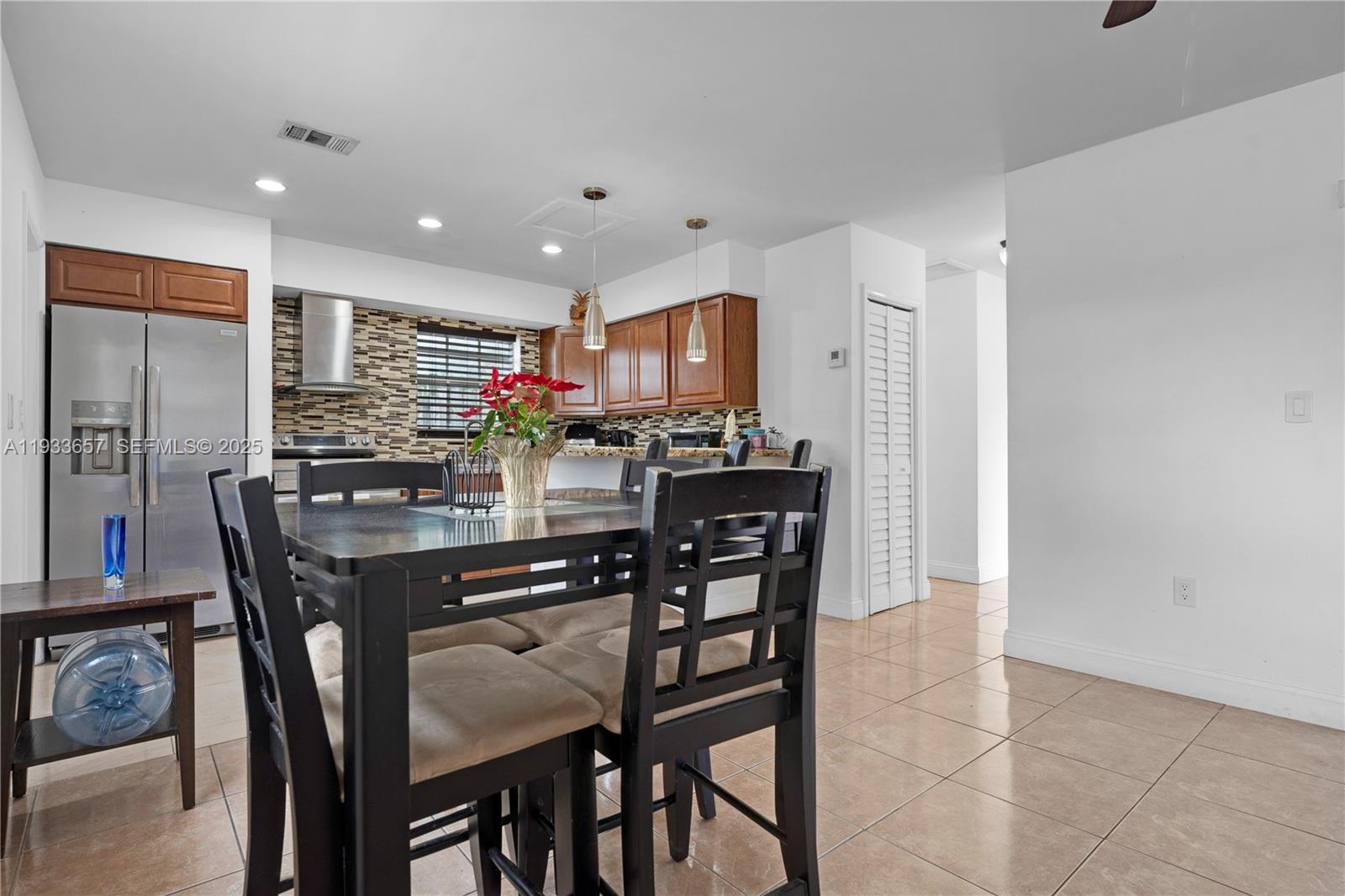 6841 Raleigh Street Hollywood, FL 33024 - Photo 9 of 41 a kitchen with a dining table chairs and refrigerator