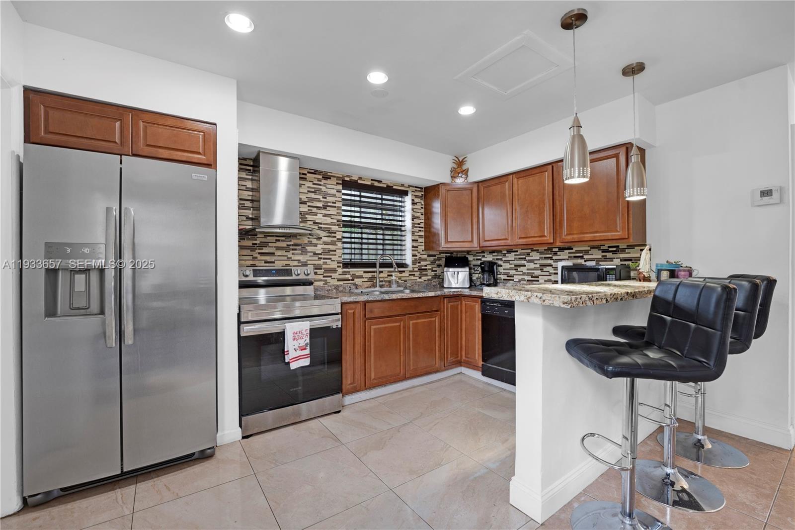 6841 Raleigh Street Hollywood, FL 33024 - Photo 10 of 41 a kitchen with stainless steel appliances granite countertop a refrigerator a stove a sink and a microwave