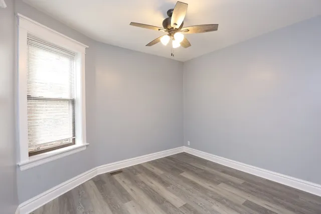 an empty room with closet and windows