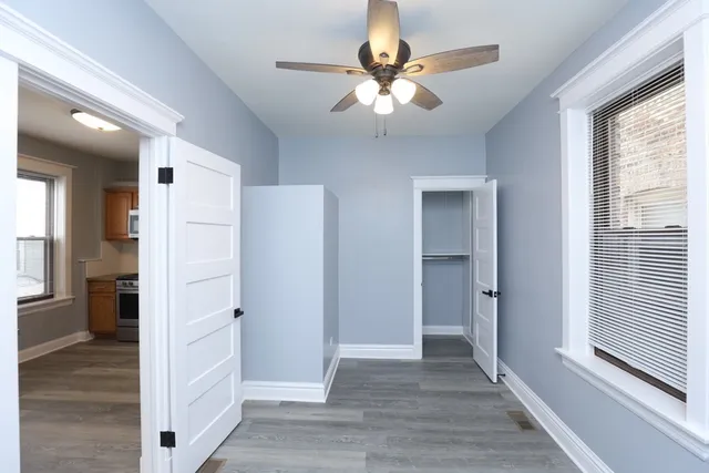 a view of a livingroom with wooden floor and a ceiling fan