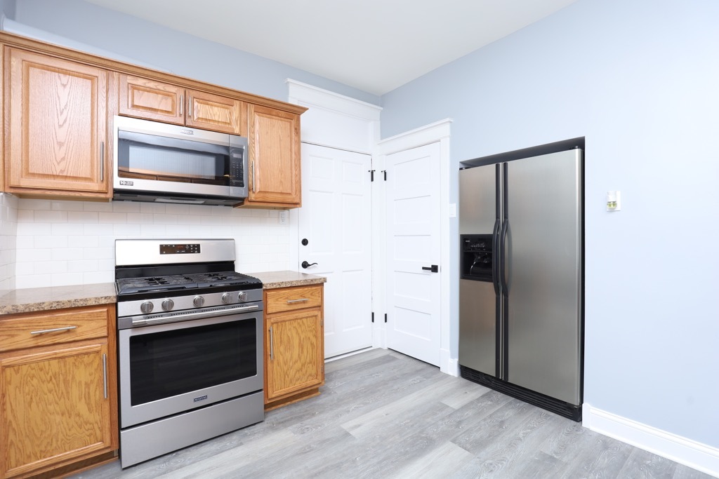 2039 West 23rd Street, Unit 1 Chicago, IL 60608 - Photo 4 of 20 a kitchen with stainless steel appliances a stove a microwave and a refrigerator
