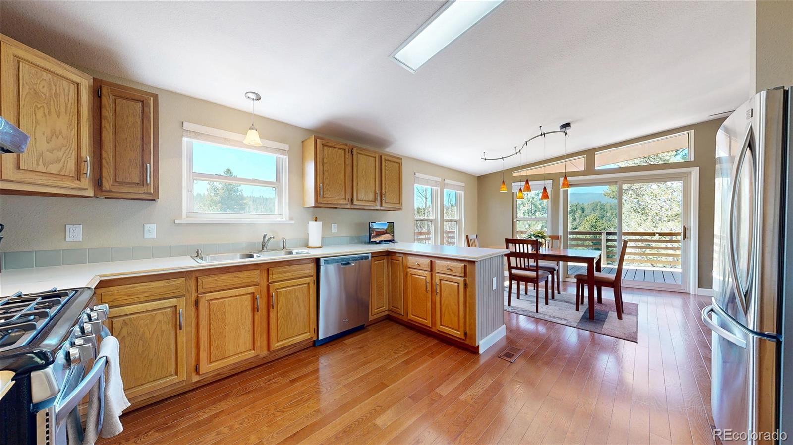 53 O'Brien Road Bailey, CO 80421 - Photo 13 of 49 a kitchen with wooden floors sink table and chairs
