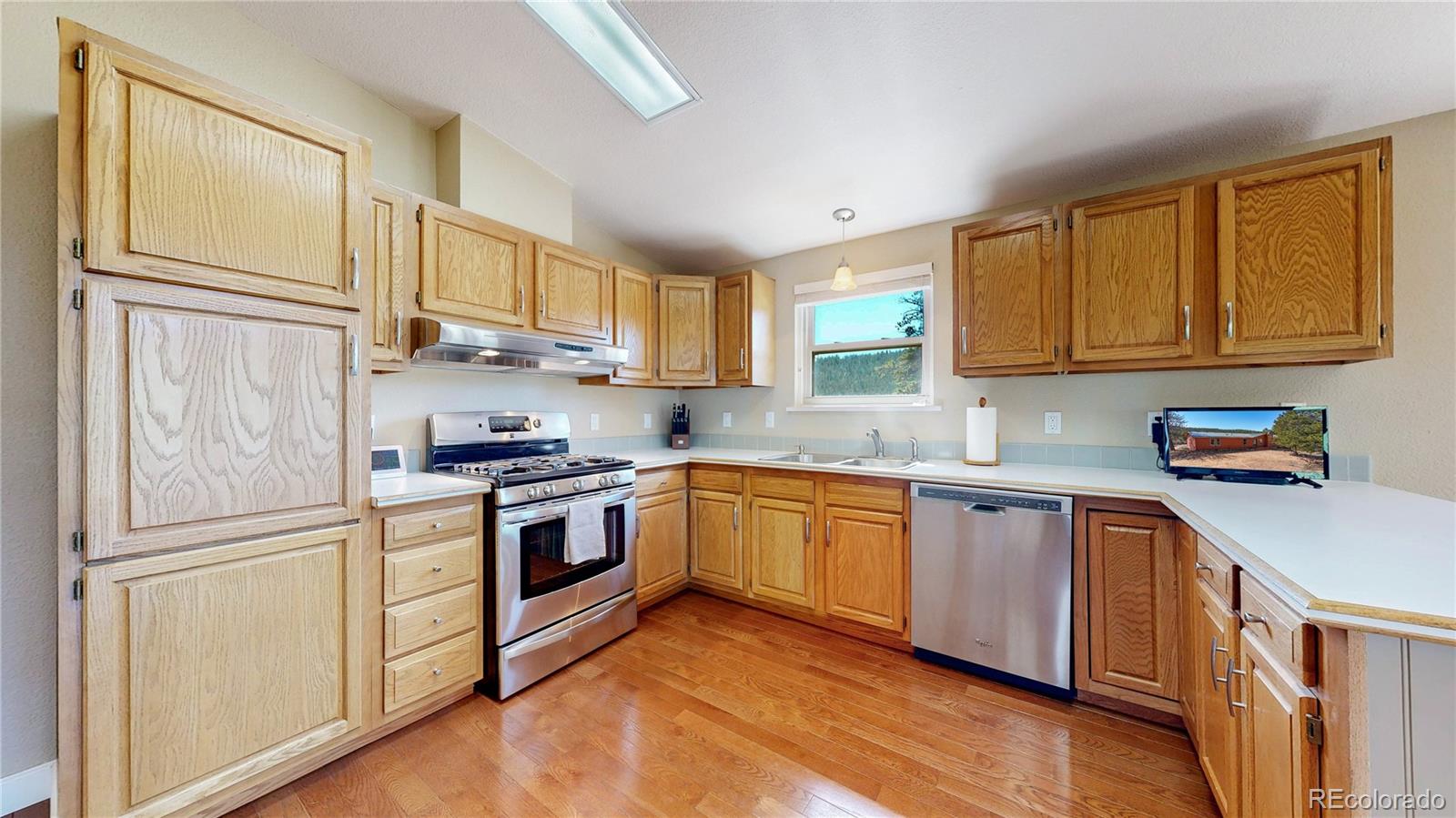 53 O'Brien Road Bailey, CO 80421 - Photo 14 of 49 a kitchen with stainless steel appliances granite countertop a refrigerator sink and wooden cabinets